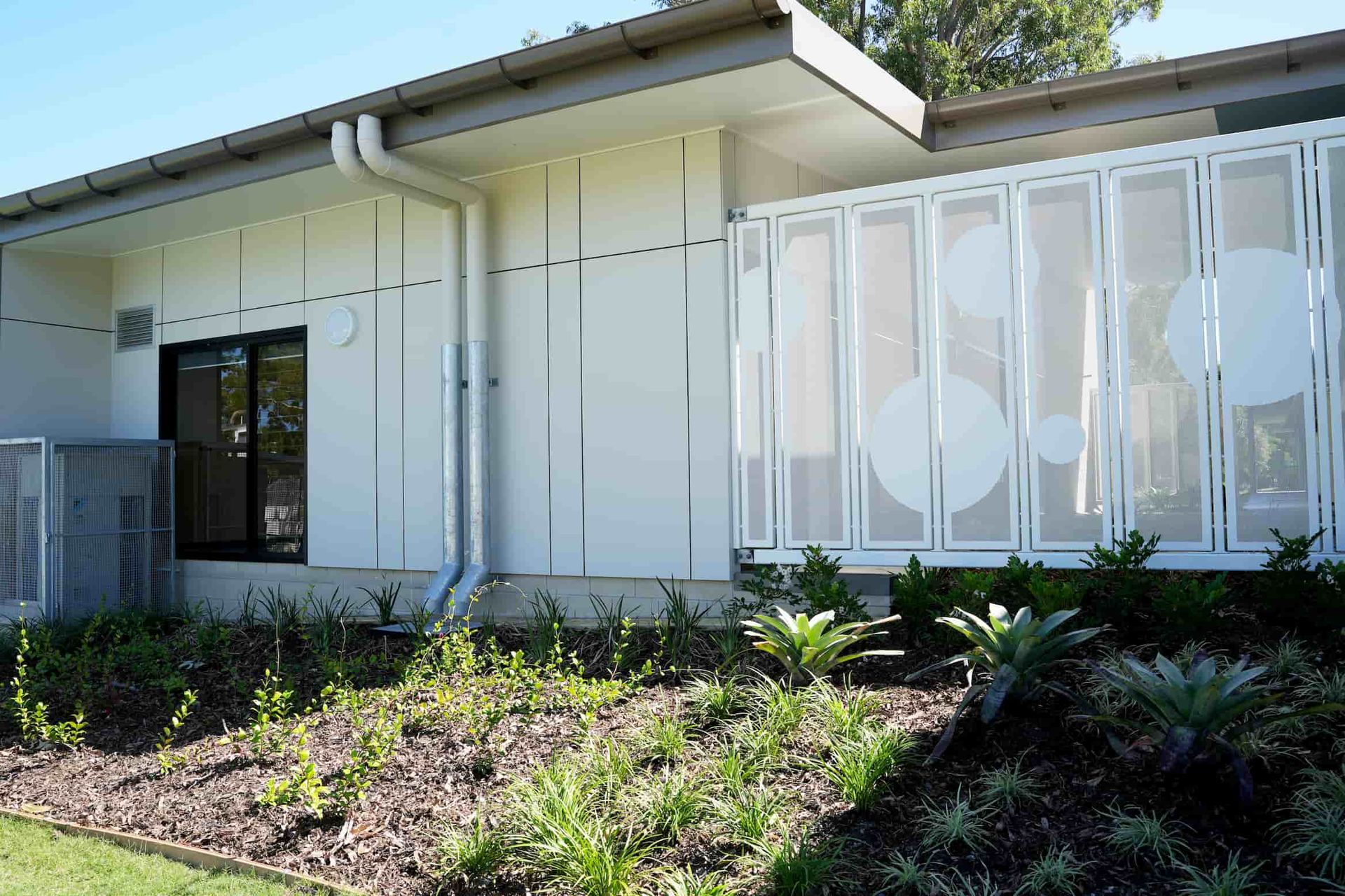a white building with a fence that has circles on it 