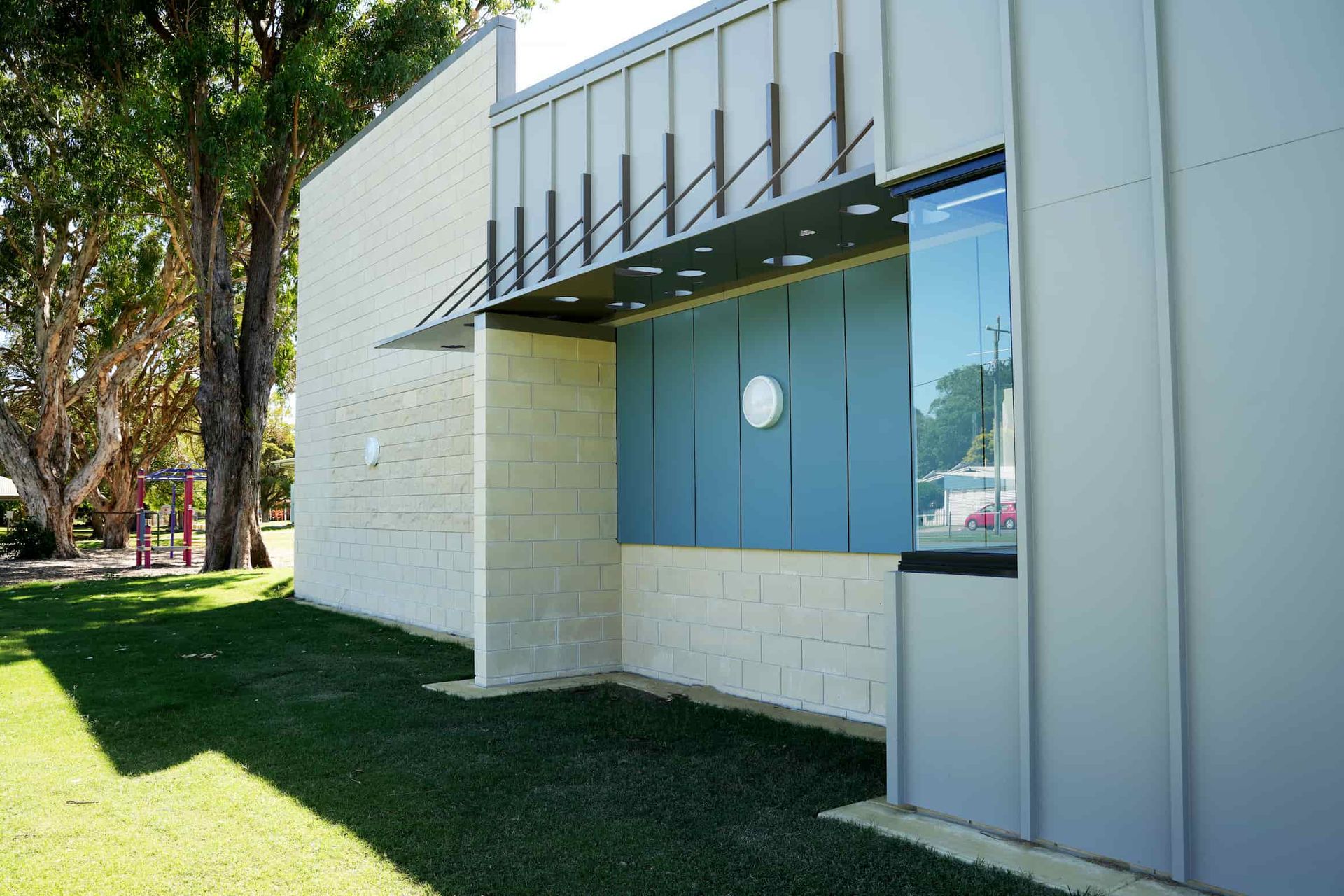 a blue and white building with a playground in the background
