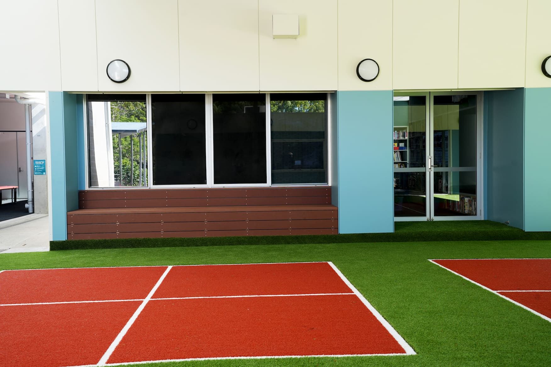 a red and white sports court with a bench in the background
