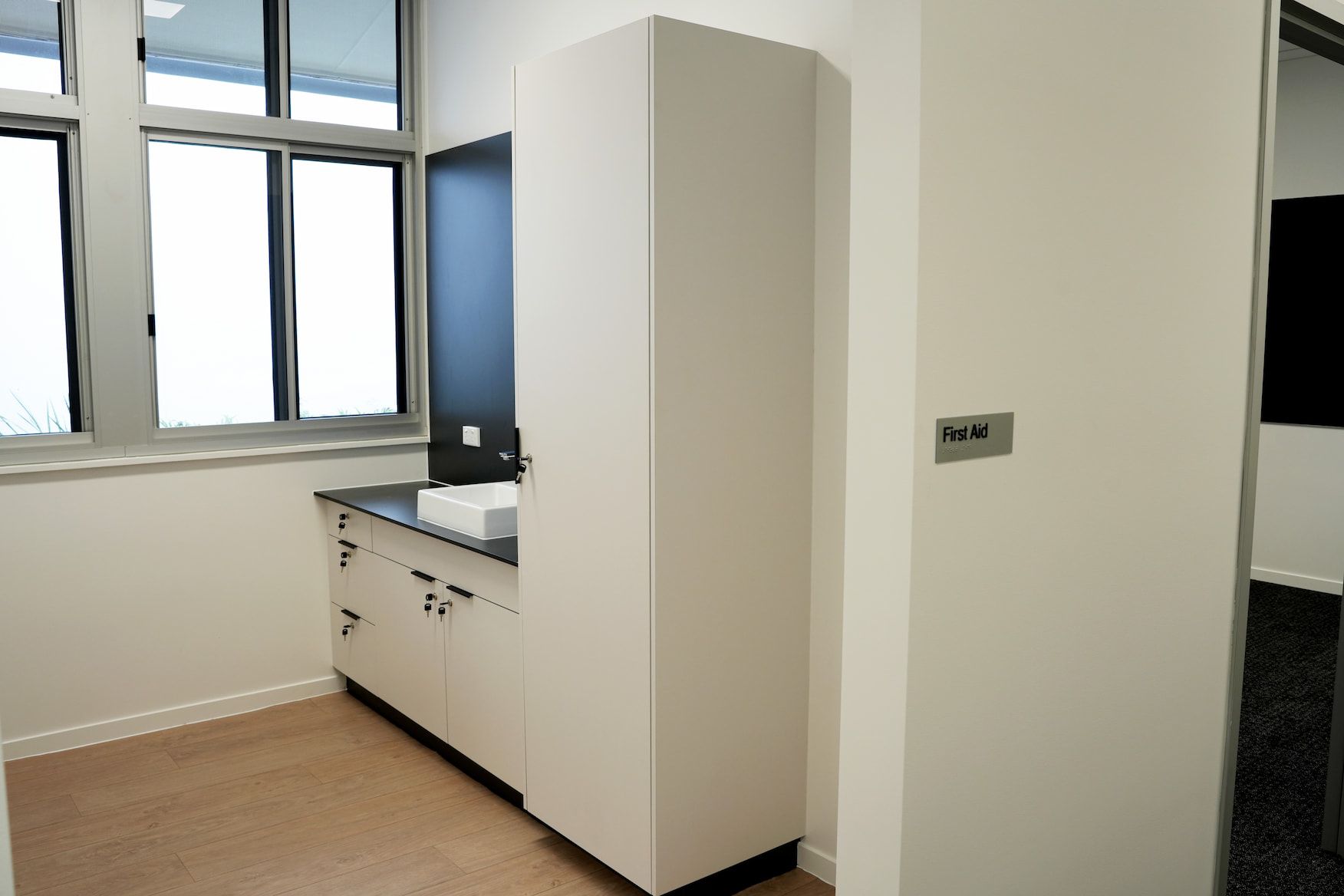 a bathroom with a sink and a sign that says first aid