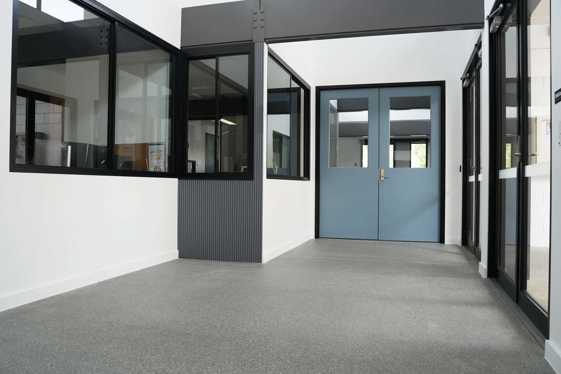 a hallway with blue doors and a lot of windows at Shailer Park SHS Health Hub