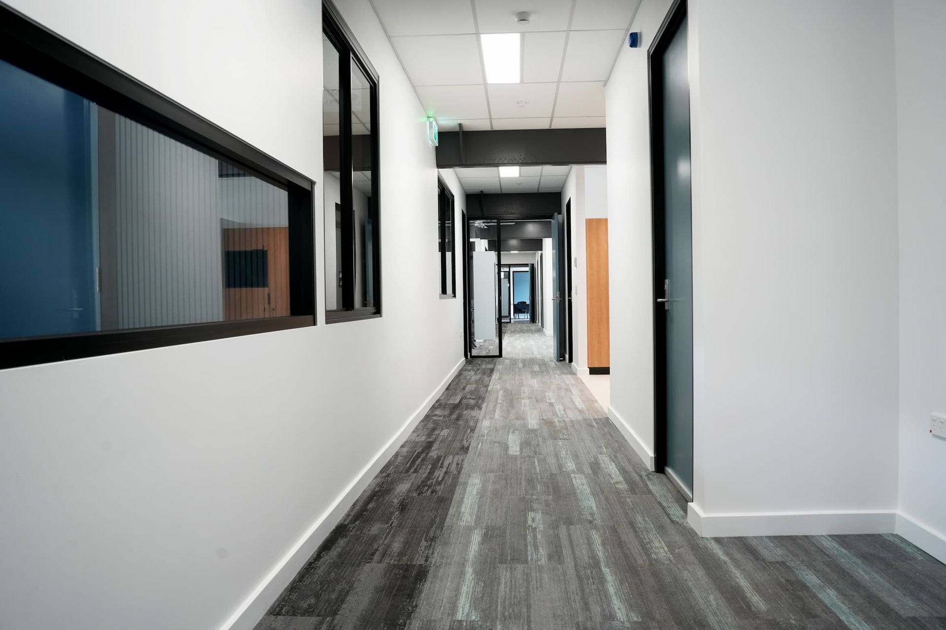 a long hallway with a carpeted floor and a lot of windows at Shailer Park SHS Health Hub