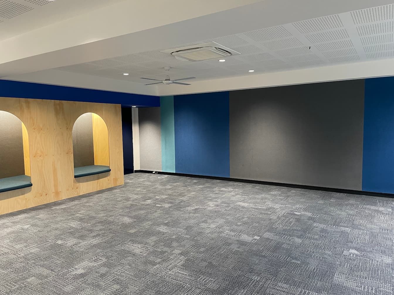 an empty room with blue walls and a ceiling fan