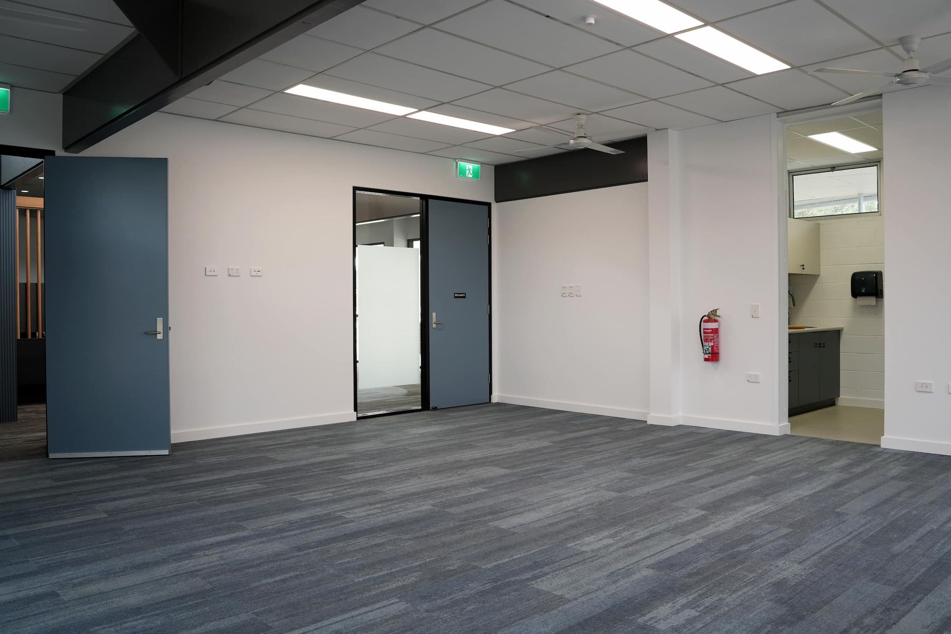 a large empty room with a fire extinguisher on the wall at Shailer Park SHS Health Hub