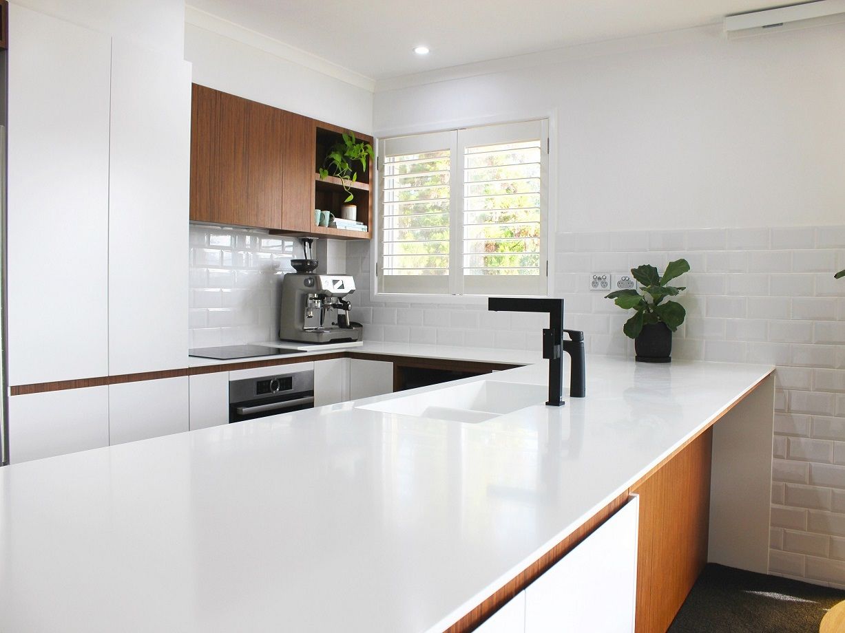 a kitchen with a coffee maker, sink and custom cabinets