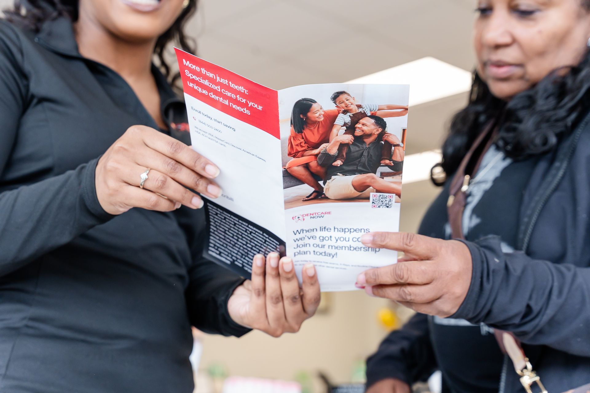 Two people hold a brochure showing a brochure at DentCare Now, emergency dentist serving Fairfax, VA