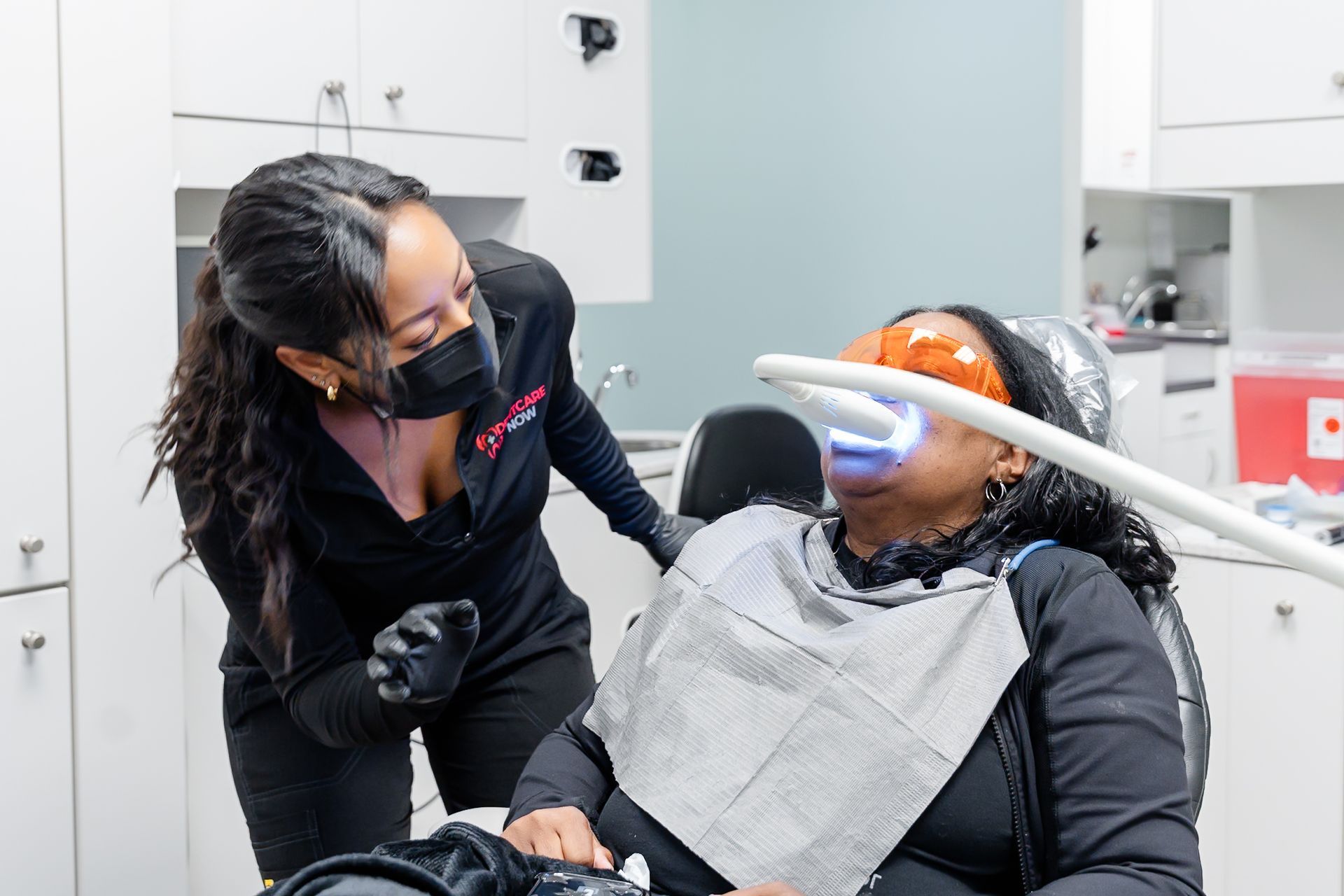 Clinician leaning over reclining patient during a dental procedure at DentCare Now, emergency dentist serving Fairfax, VA