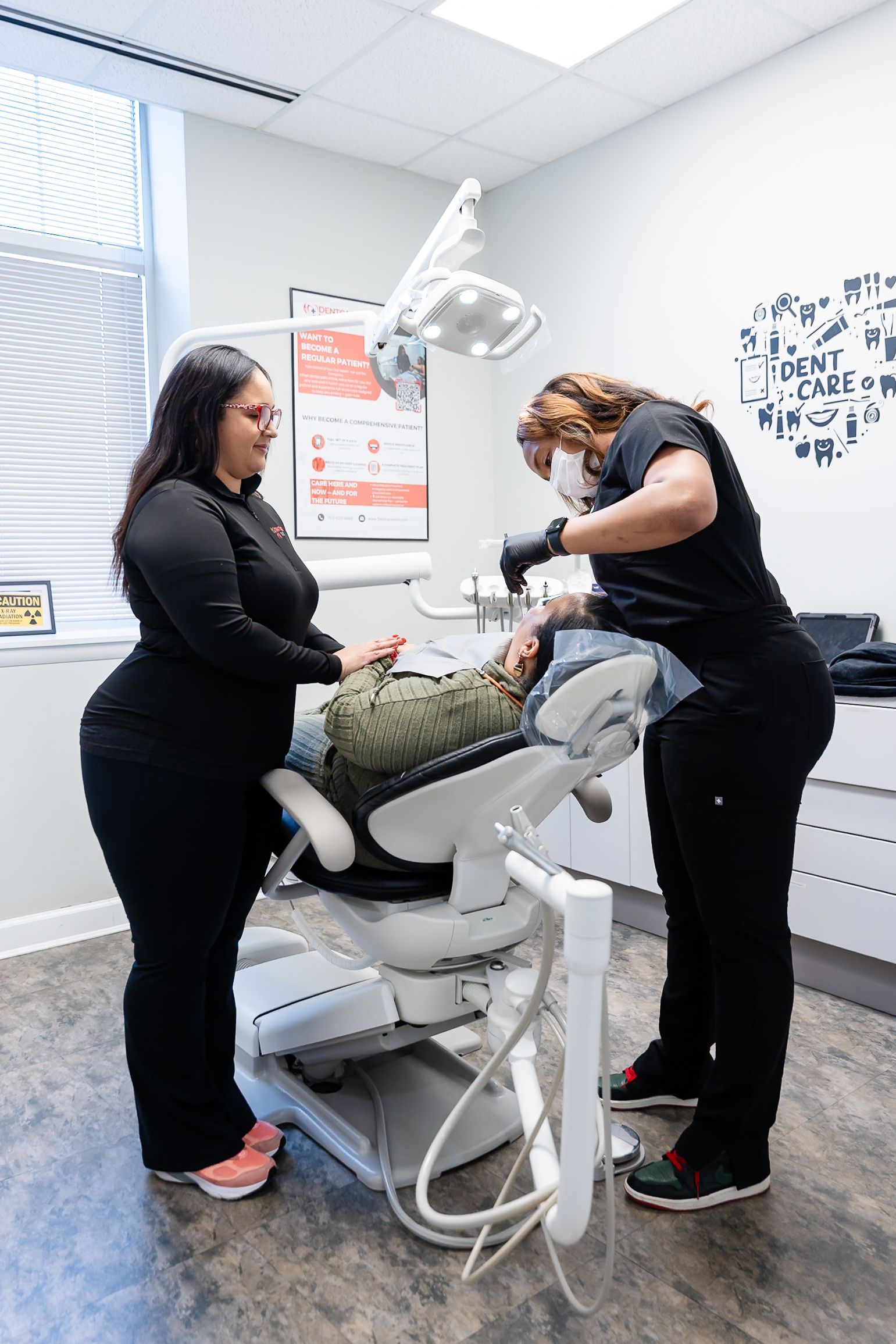Two clinicians adjusting a patient on a dental chair in a exam room at DentCare Now, emergency dentist serving Fairfax, VA