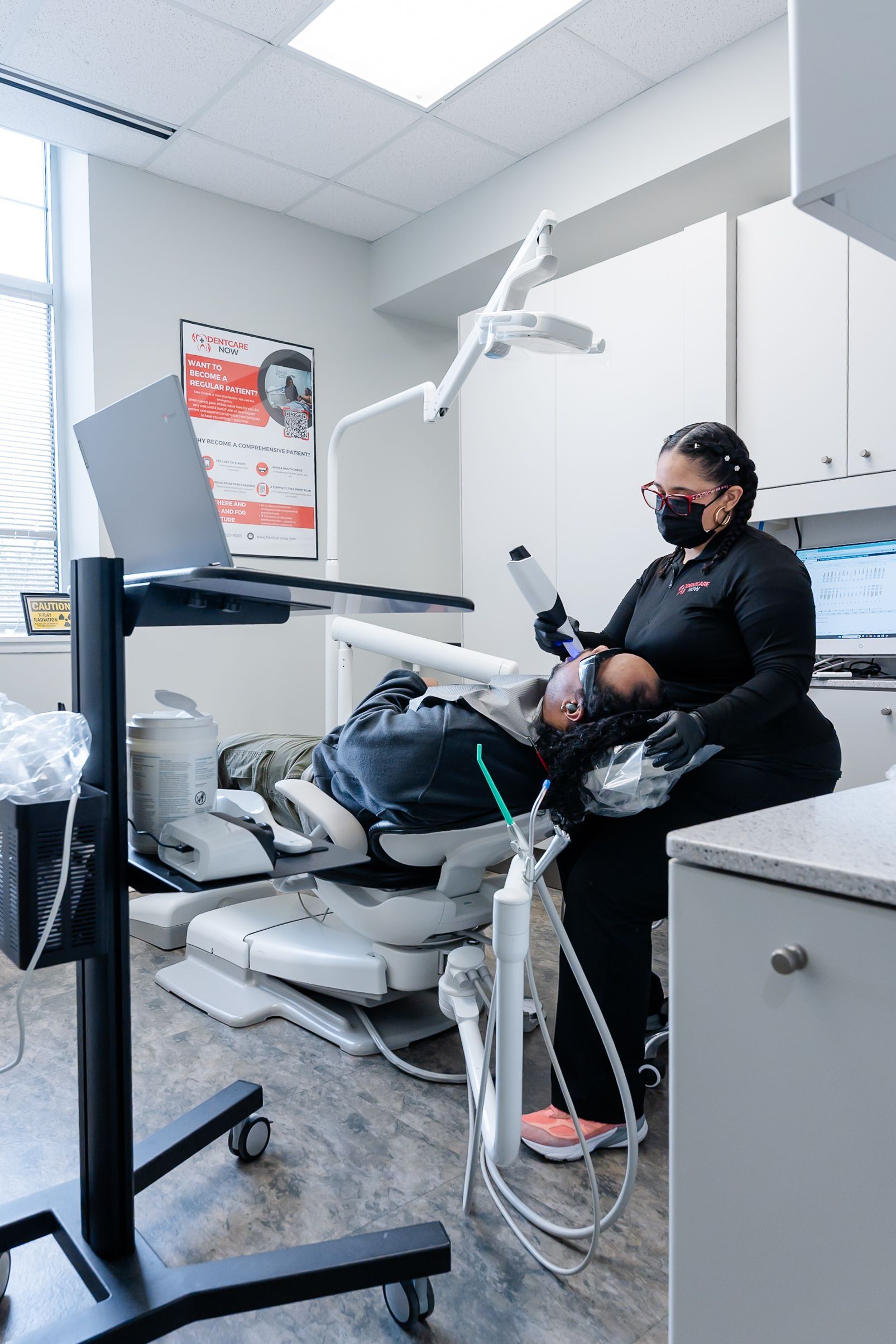 Dentist treating a patient in a dental chair in a clinic at DentCare Now, emergency dentist serving Fairfax, VA