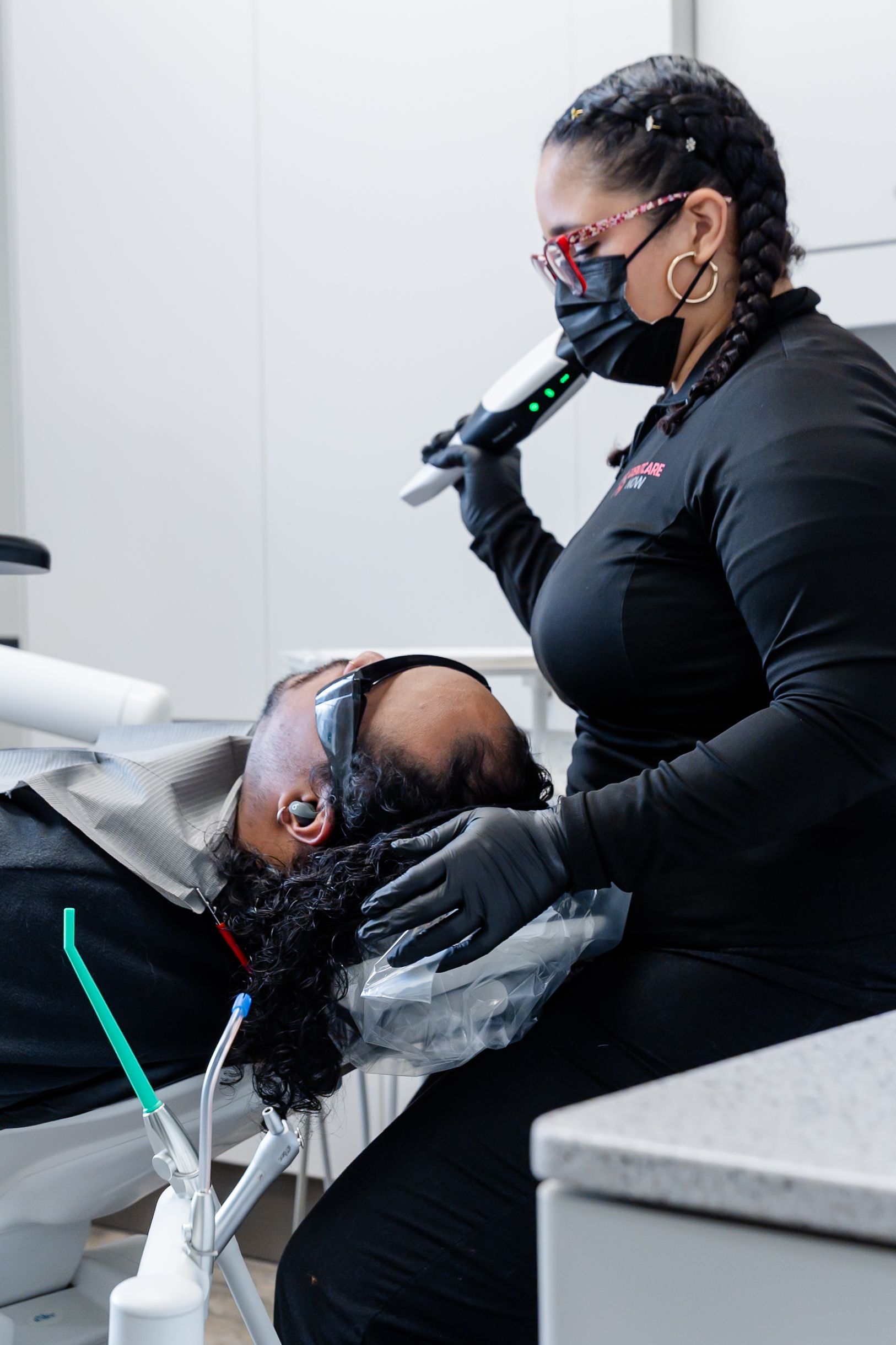 Dentist examining a patient in a chair, wearing gloves and a mask at DentCare Now, emergency dentist serving Fairfax, VA