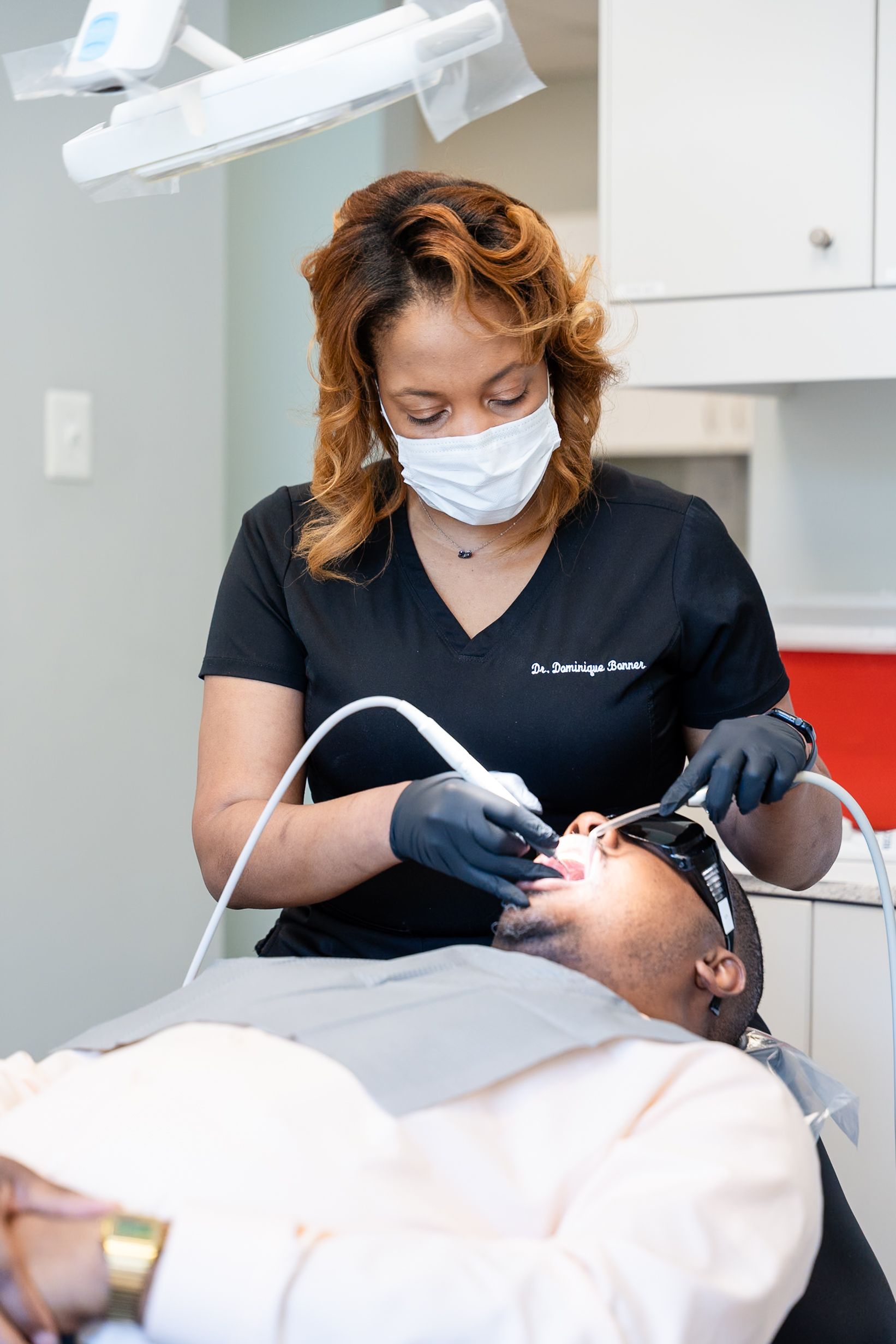 Dentist wearing mask and gloves treats a patient in a dental chair at DentCare Now, emergency dentist serving Fairfax, VA