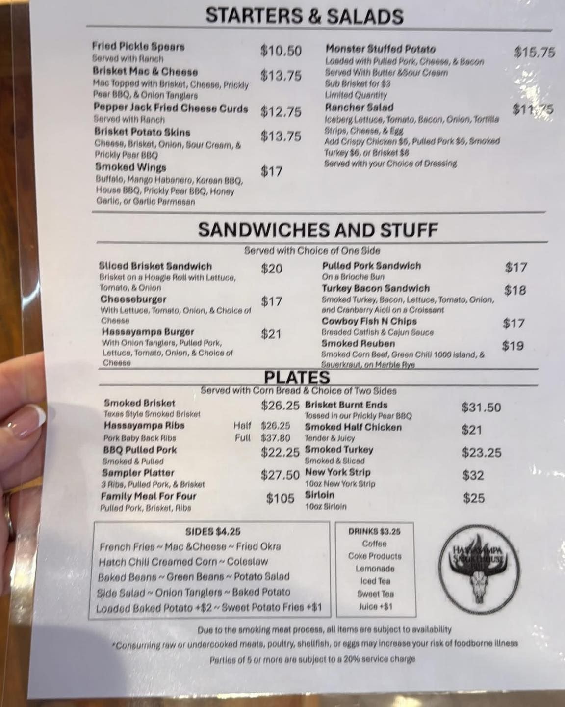 Blurry restaurant menu with sections for starters, salads, sandwiches, and plates.