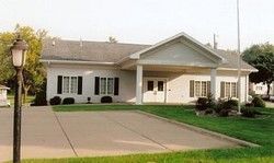 Single-story suburban house with a covered front porch, driveway, and neatly kept lawn