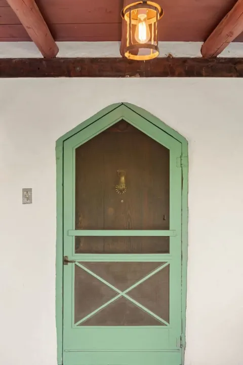 The Boyle House’s green doorway set in thick adobe walls