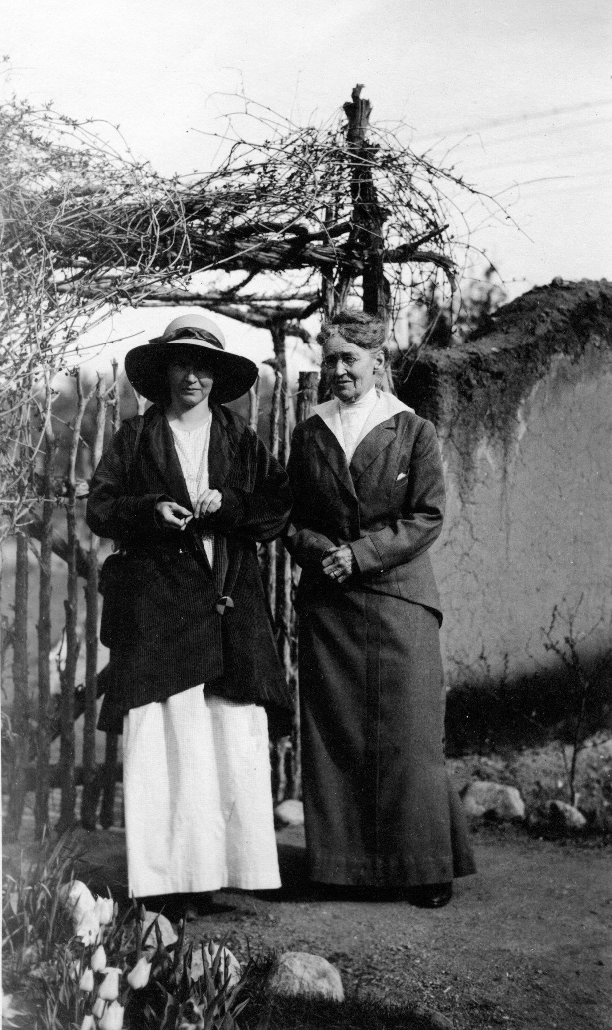 Two women beside the Boyle House courtyard wall in an archival photograph