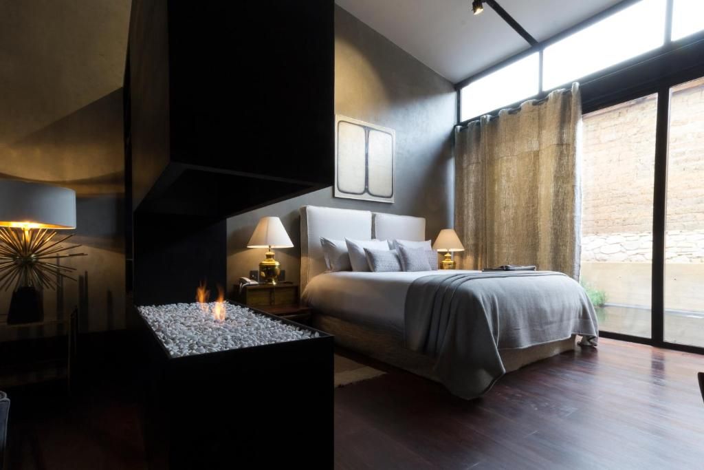 Un dormitorio con chimenea y una cama grande.