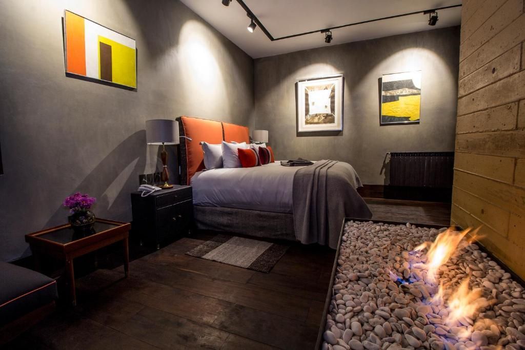 Un dormitorio con una cama y una chimenea en la esquina.