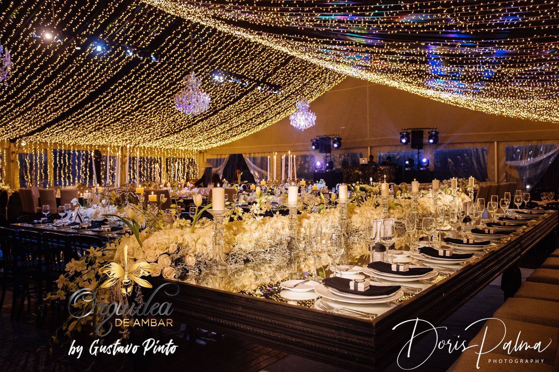 A long table with a lot of flowers and candles on it