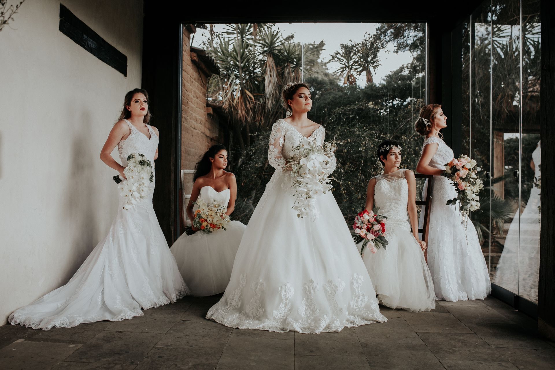 A group of women in wedding dresses are standing next to each other.