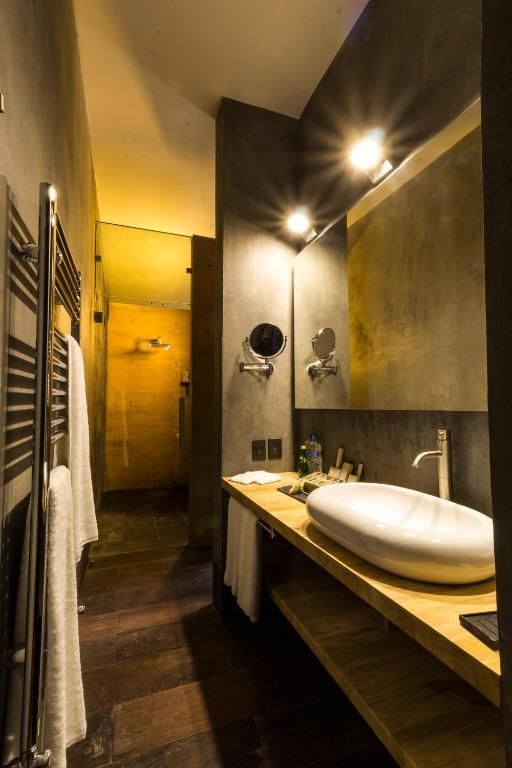 Un baño con lavabo, espejo y toallero.