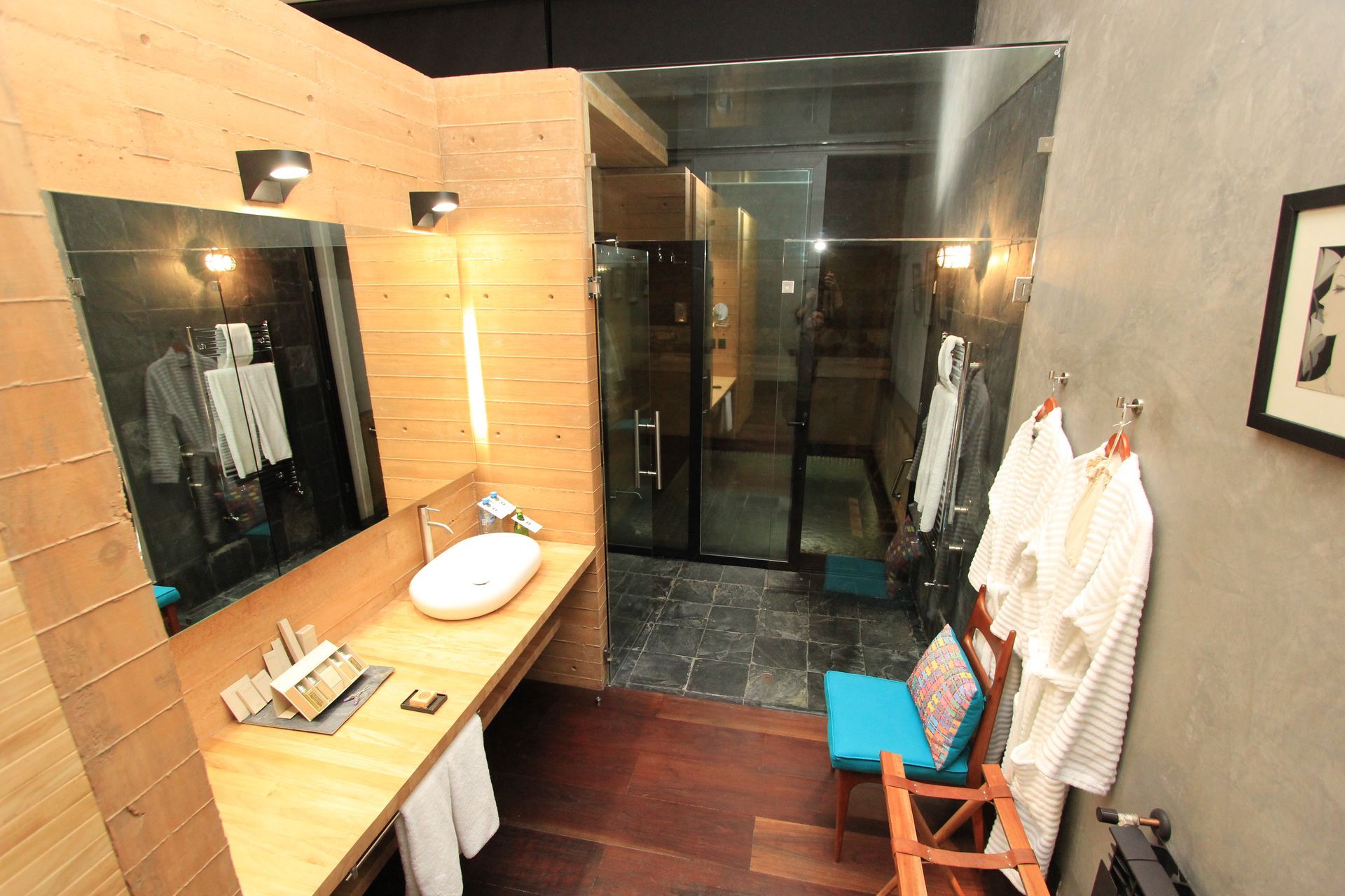 Un baño con un lavabo, un espejo y una silla.