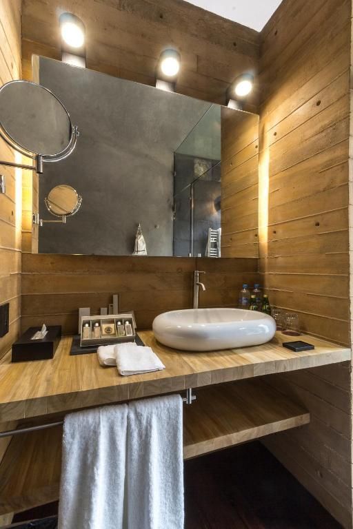 Un baño con lavabo, espejo y toallero.