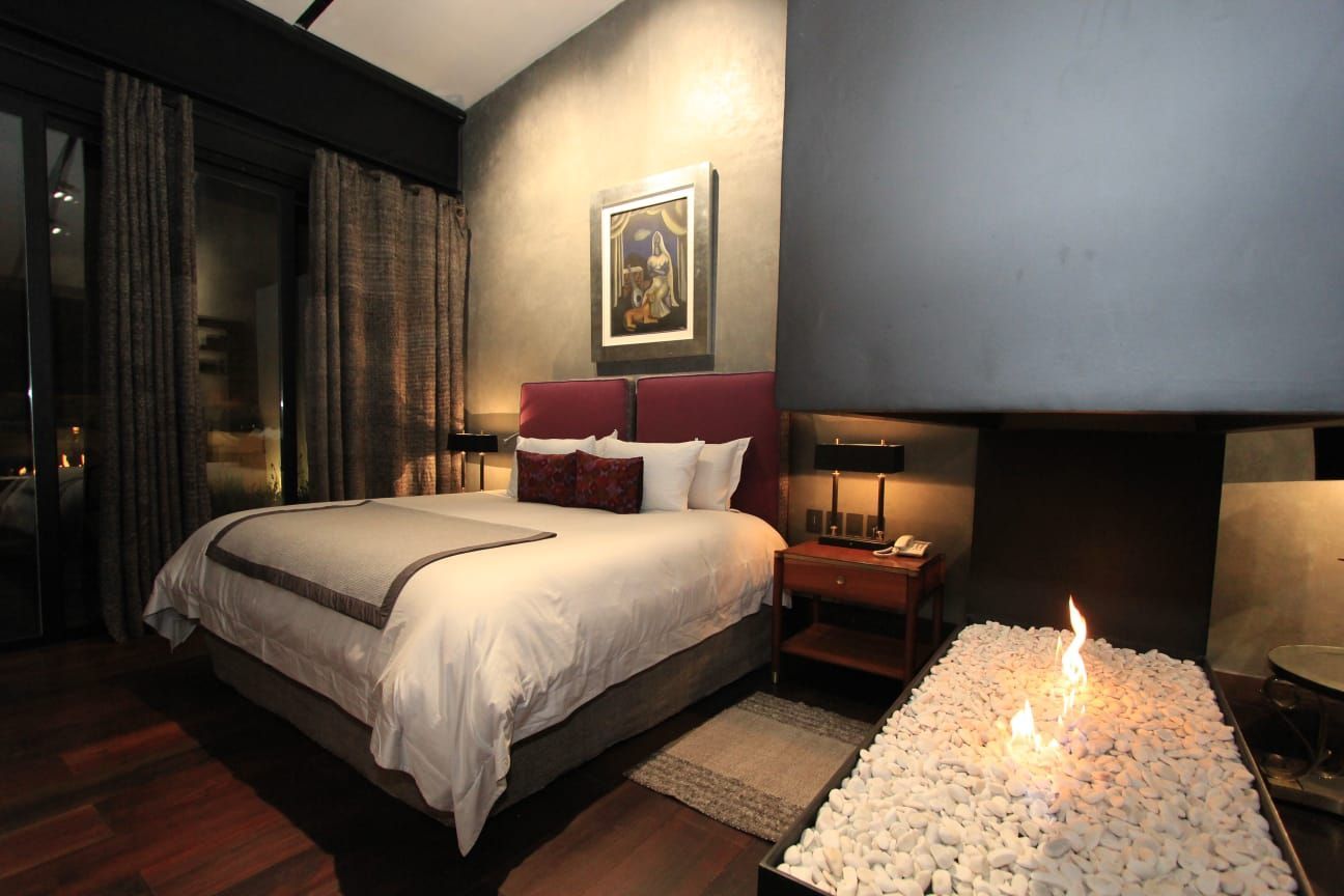 Un dormitorio con chimenea y una cama.