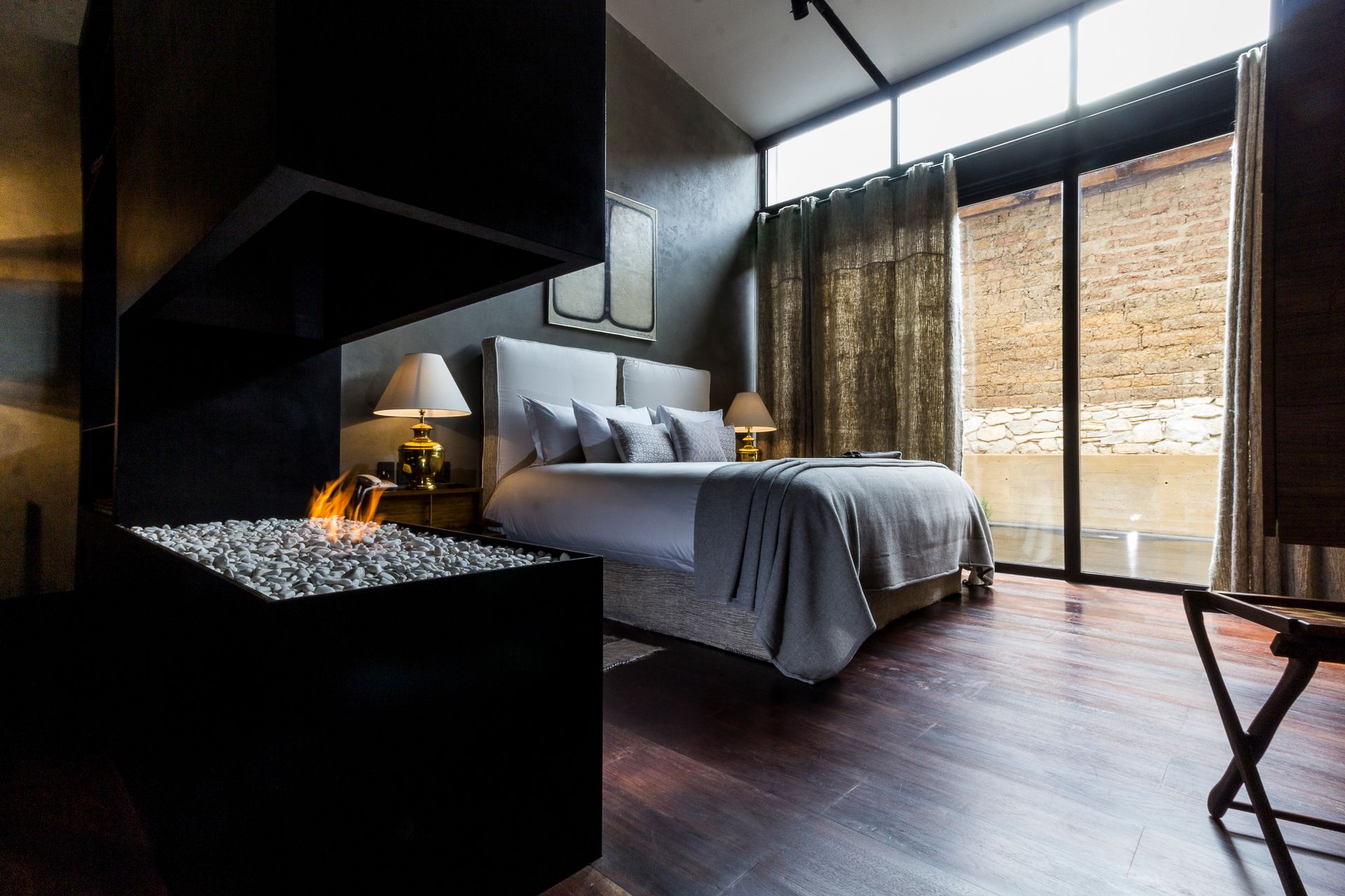 A bedroom with a large bed and a fireplace