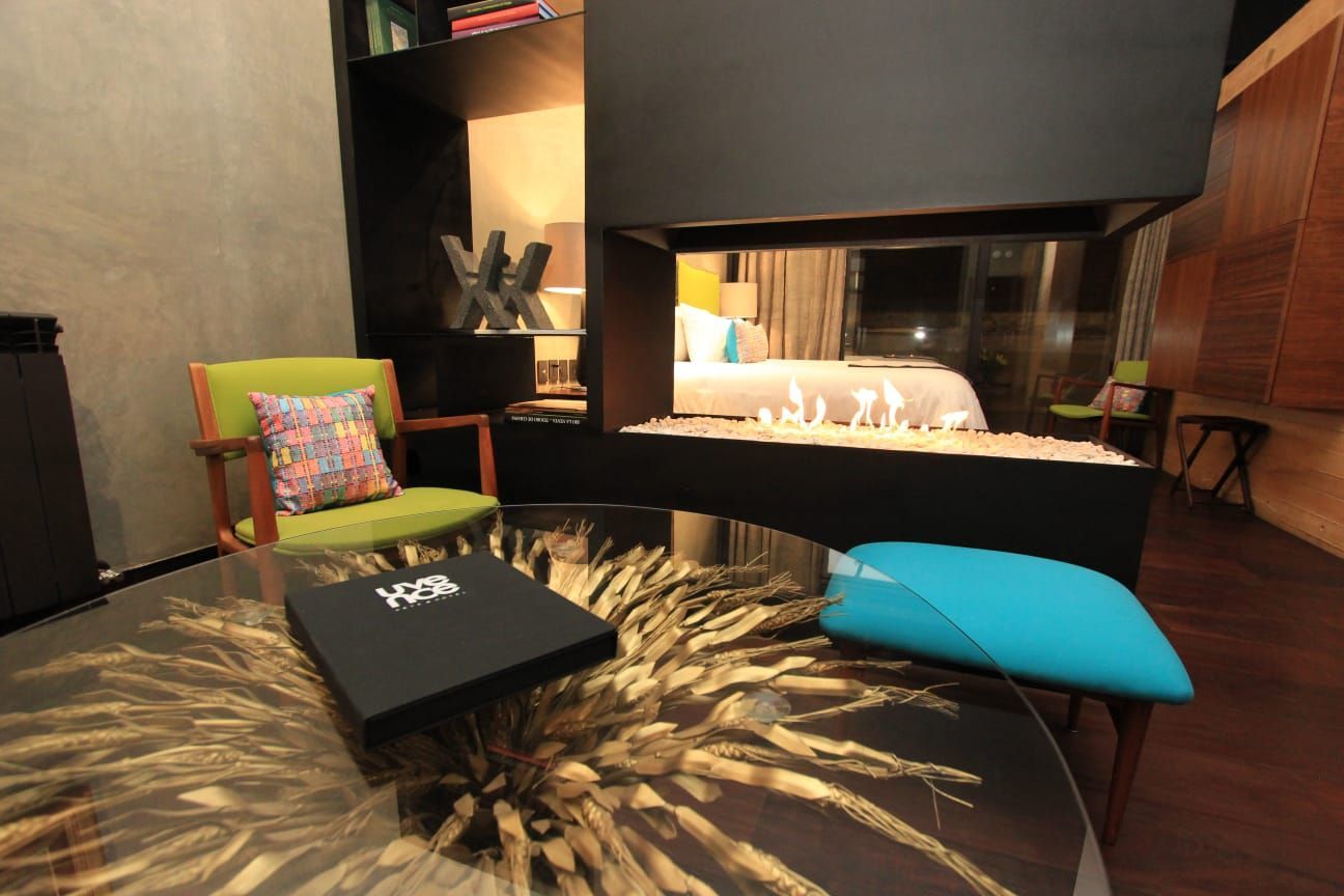 Una sala de estar con chimenea y sillas y una mesa con una caja que dice 100% en ella.