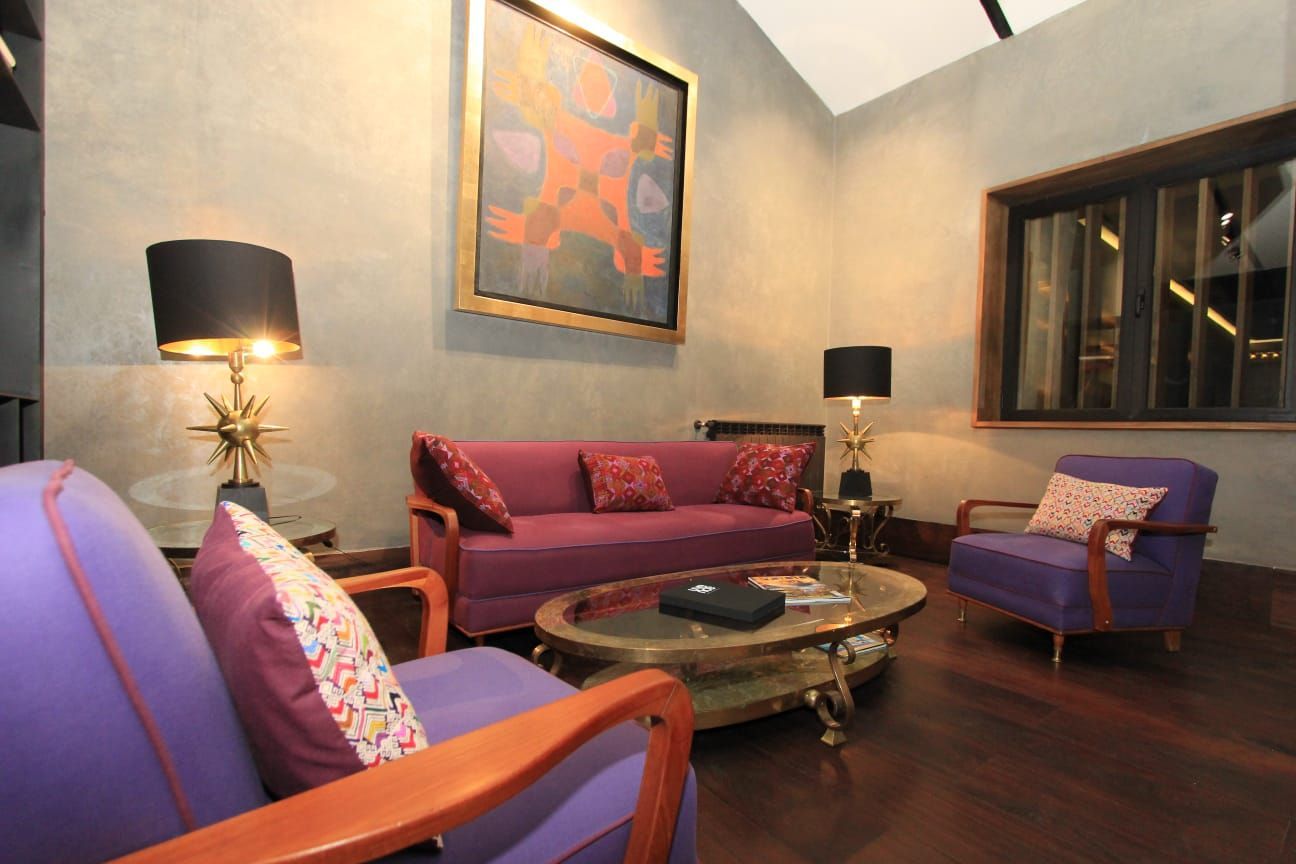 Una sala de estar con un sofá morado y sillas moradas.