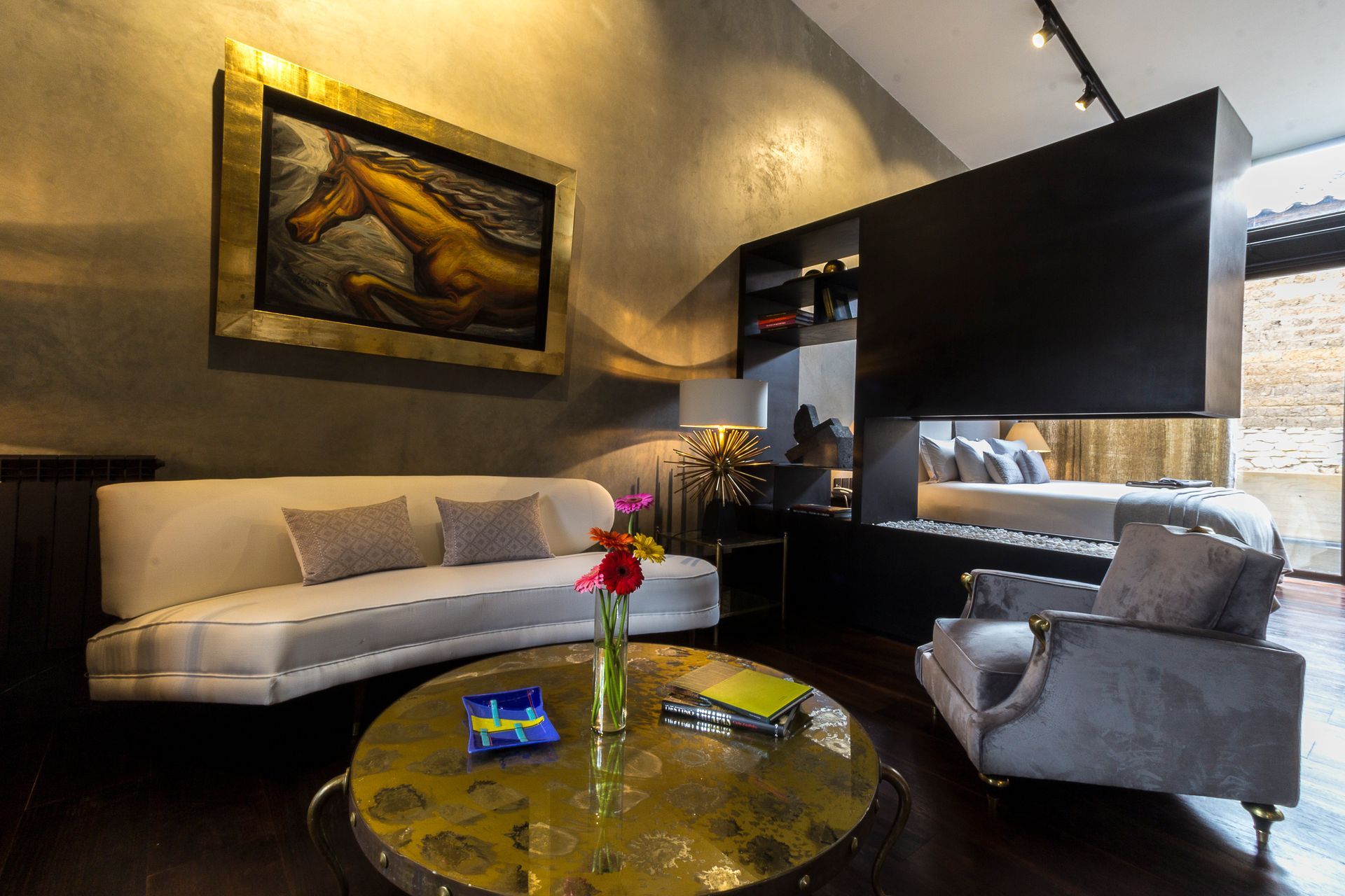 Una sala de estar con un sofá, una silla, una mesa de café y un cuadro en la pared.