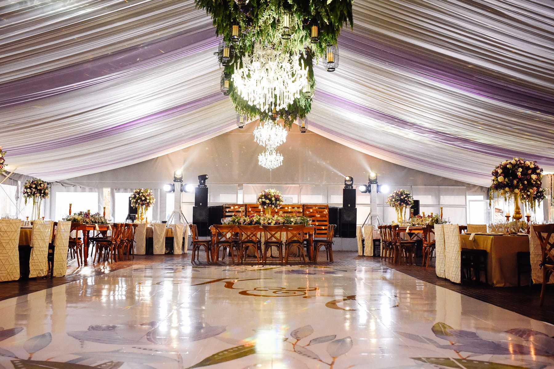 A large room with a dance floor and a chandelier hanging from the ceiling.