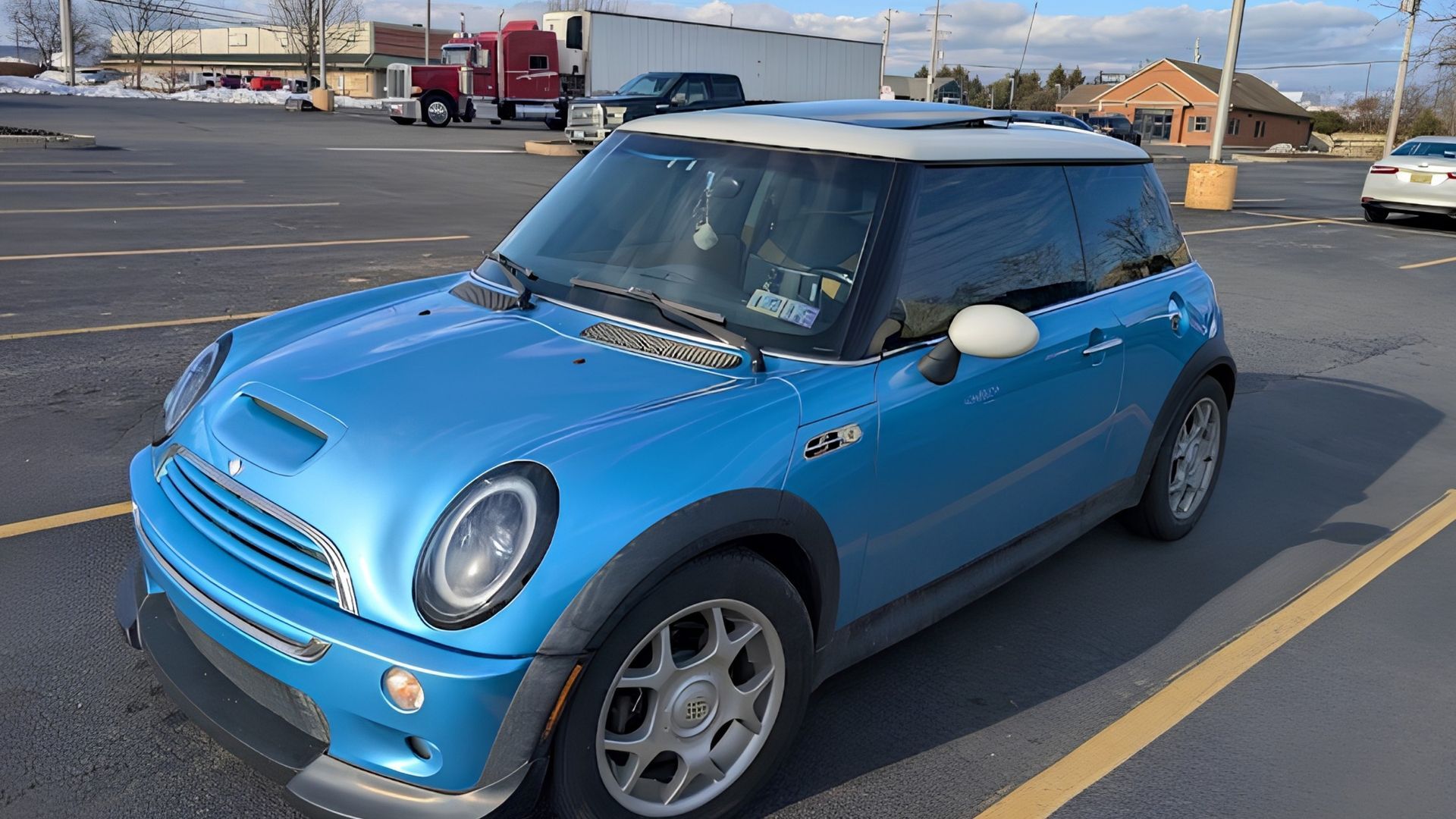 Blue Mini Cooper parked in a lot on a sunny day