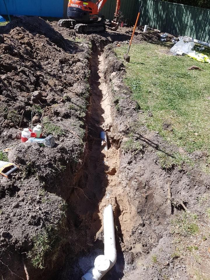 A Trench Dug in a Yard, With Plumbing Pipes Visible — Hunter Plumbing And Hotwater in Medowie, NSW