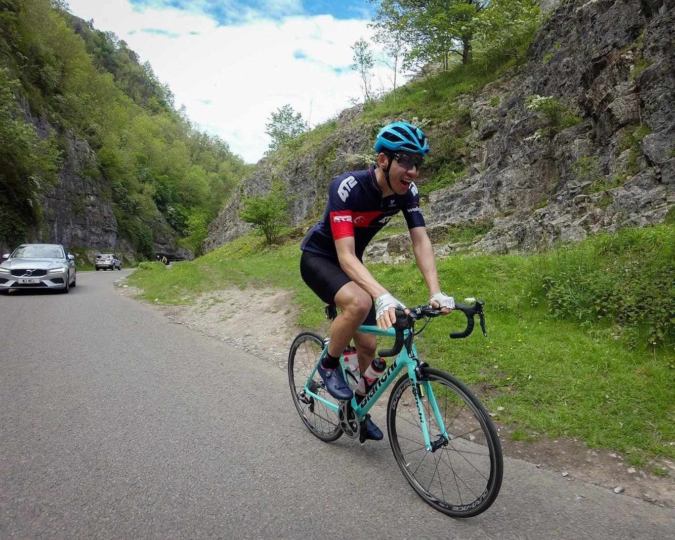 Desmond Poon riding his bike downhill and smiling
