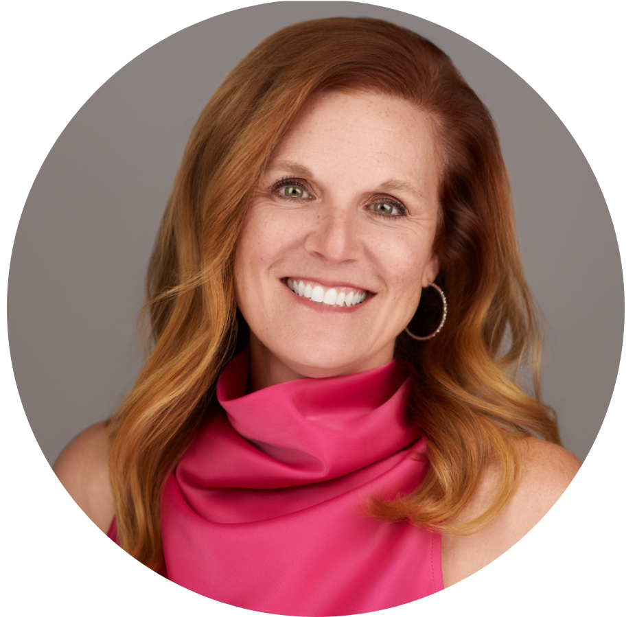 Woman with red hair, smiling in a pink blouse.