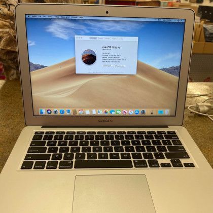 A laptop with a picture of a sand dune on the screen