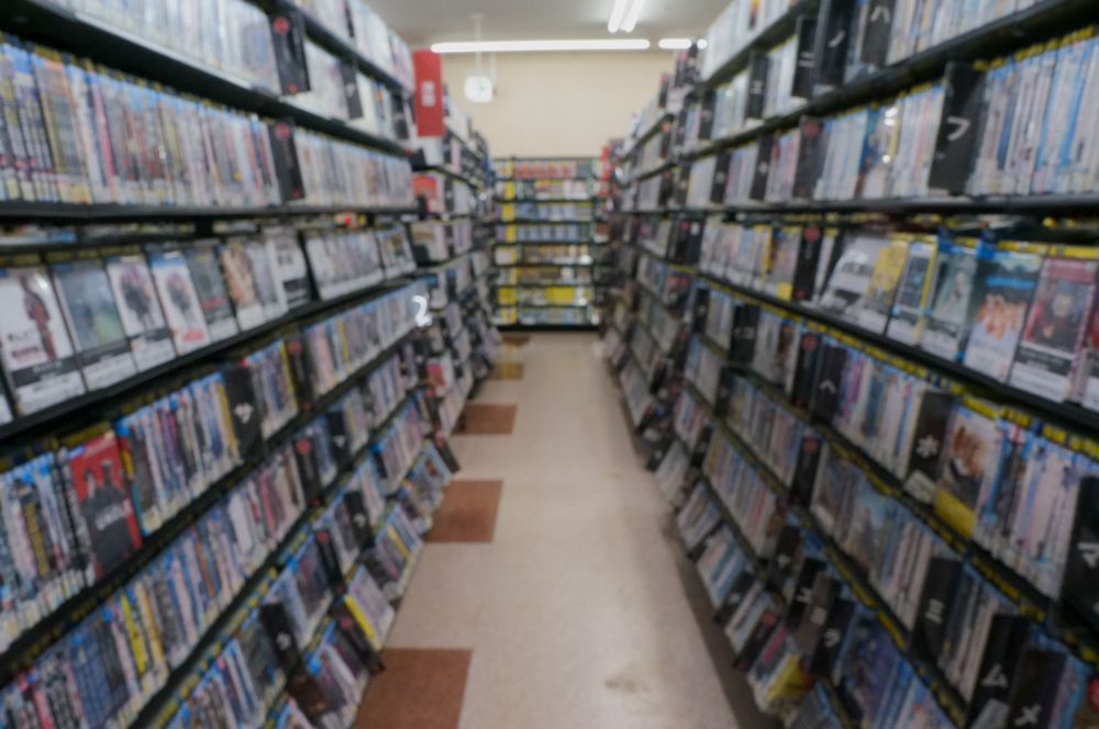 A row of shelves filled with lots of dvds in a store.