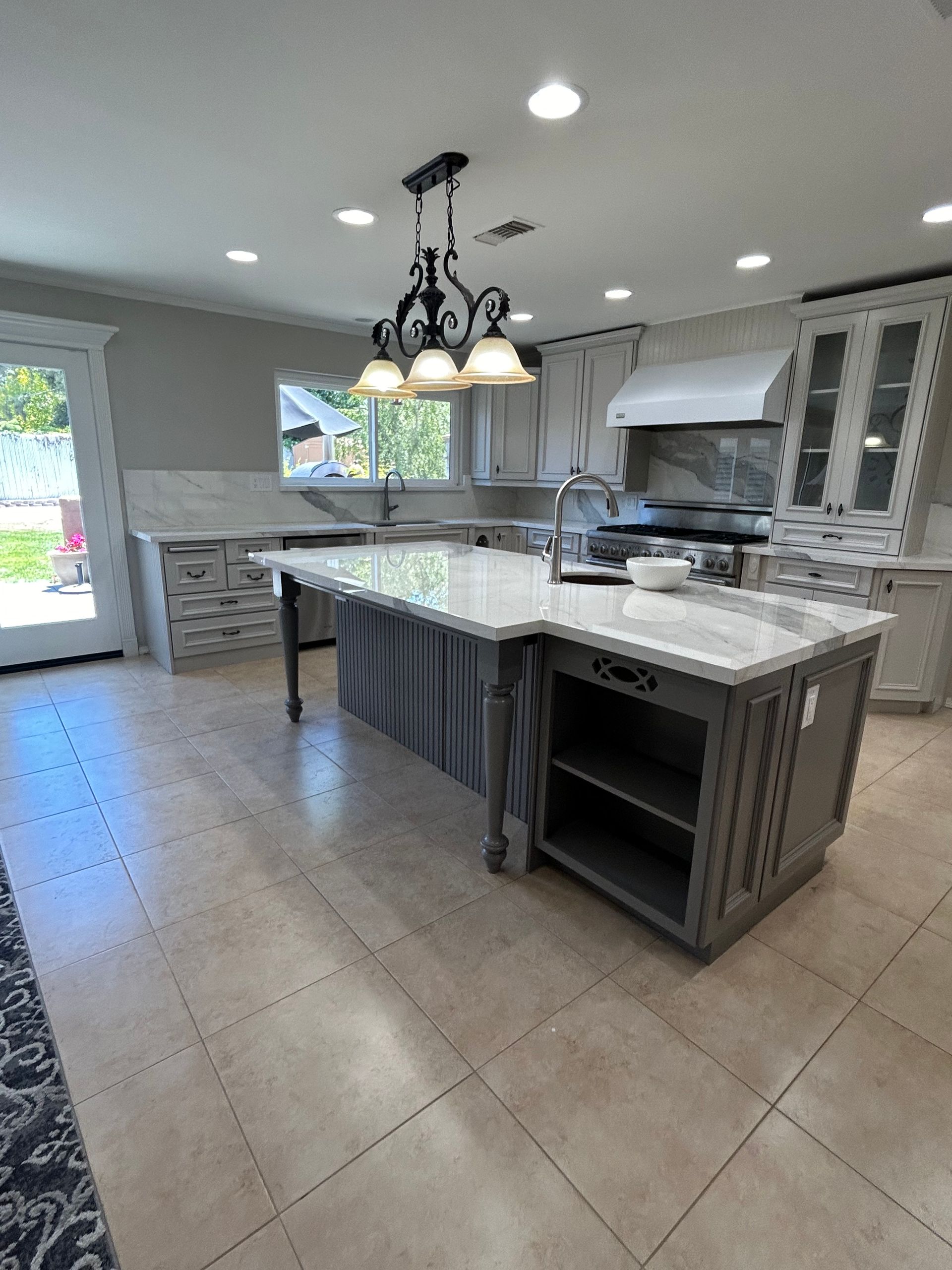 A kitchen under construction with white cabinets and a window.