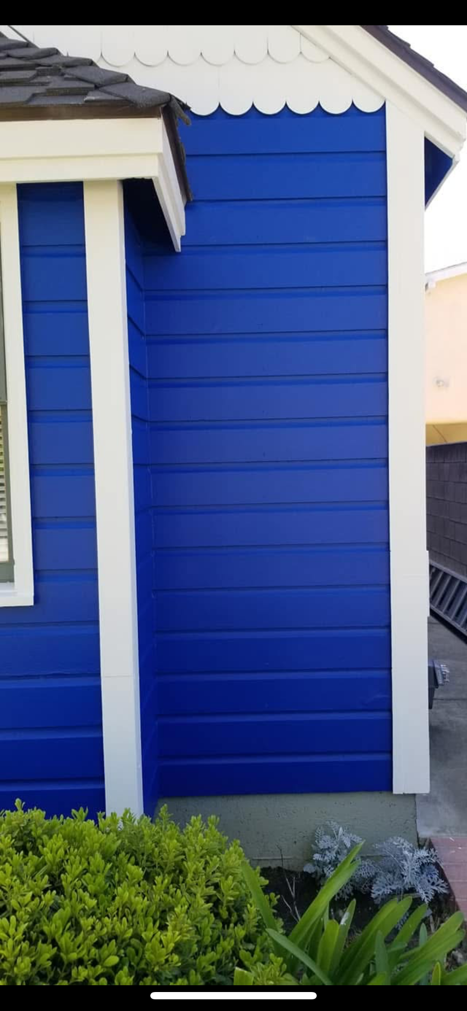 A man on a lift paints the side of a building