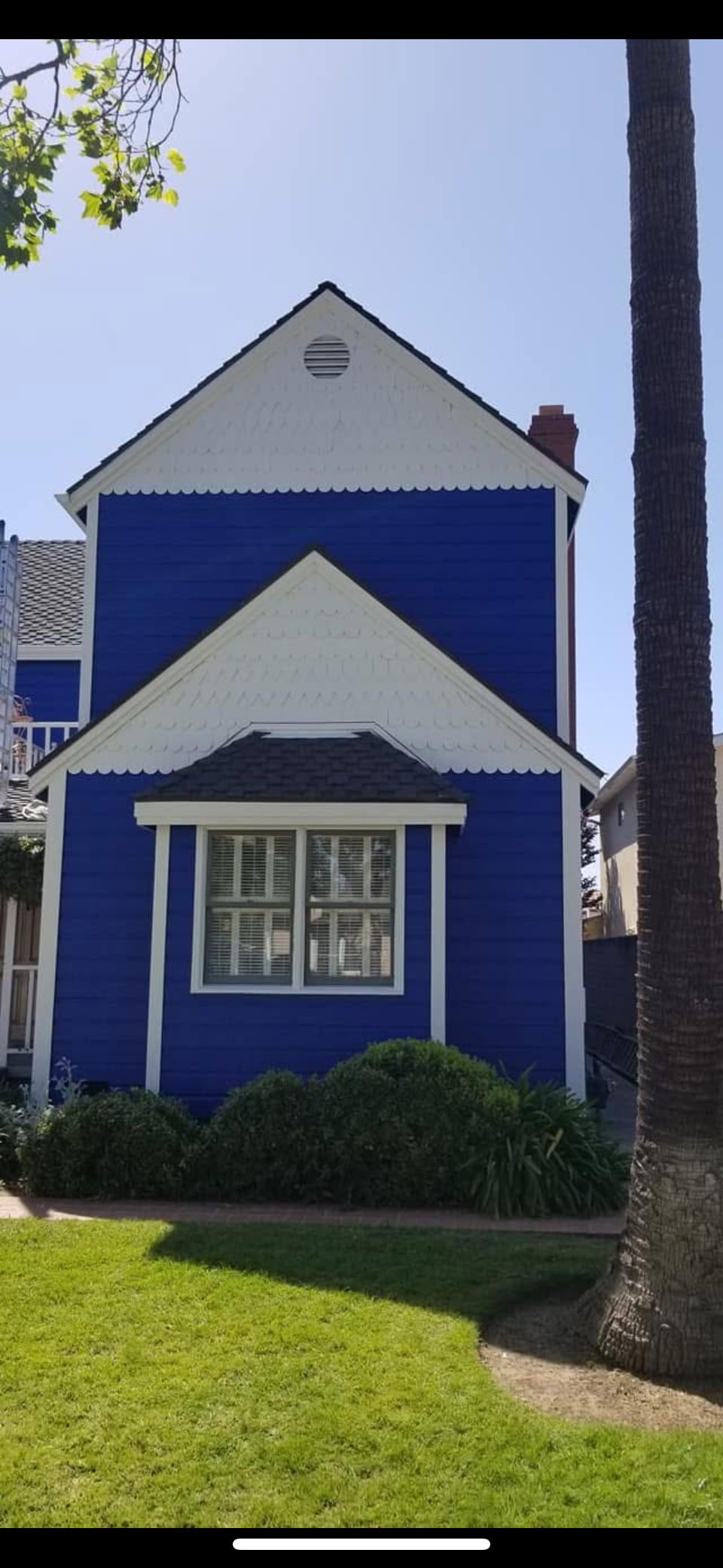 A house with a gray roof and a driveway is for sale.