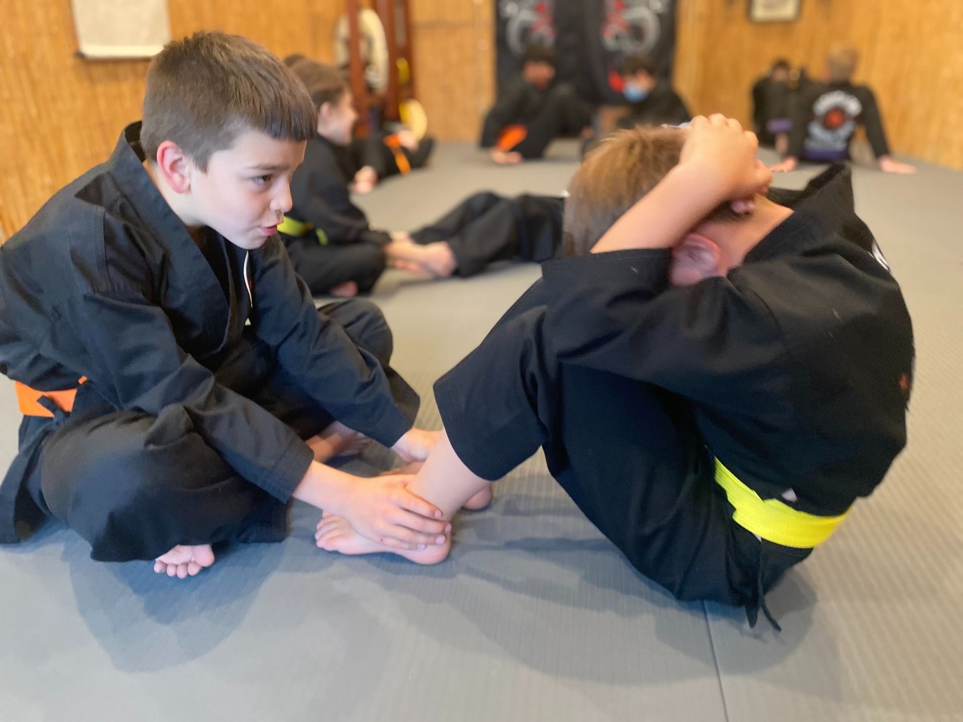 A group of young boys are practicing martial arts in a gym.