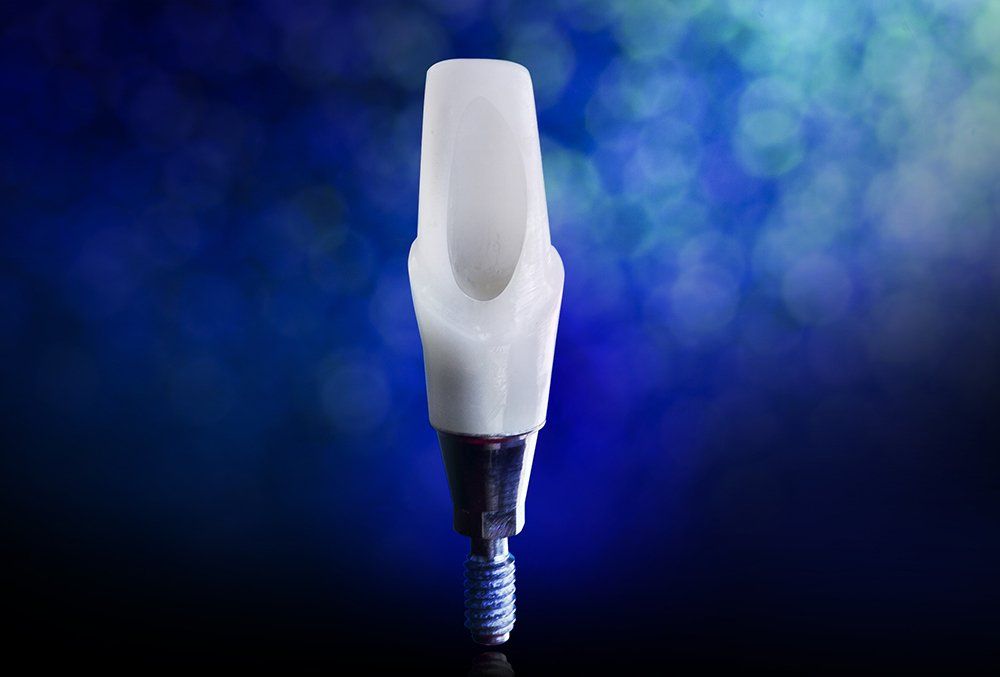 A close up of a dental implant on a blue background.