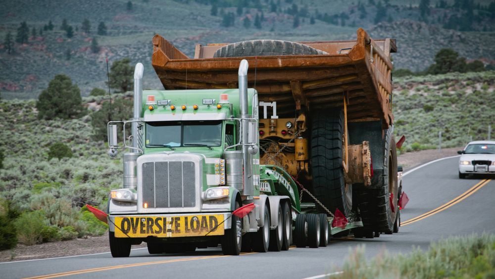 A large dump truck is driving down a road.