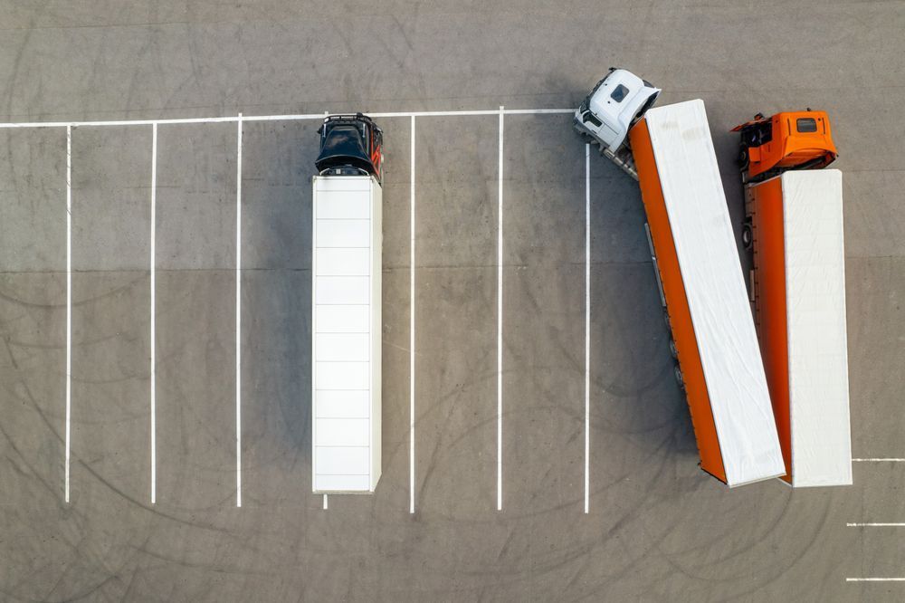 A group of semi trucks are parked in a parking lot.