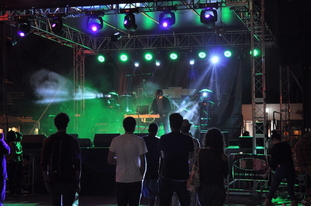 A Musician Performing On Stage With A Crowd Watching — Kennedy Amplifier Hire Service In South Mackay, QLD