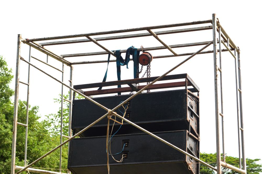 Black Speakers Stacked On A Metal Scaffolding — Kennedy Amplifier Hire Service In South Mackay, QLD
