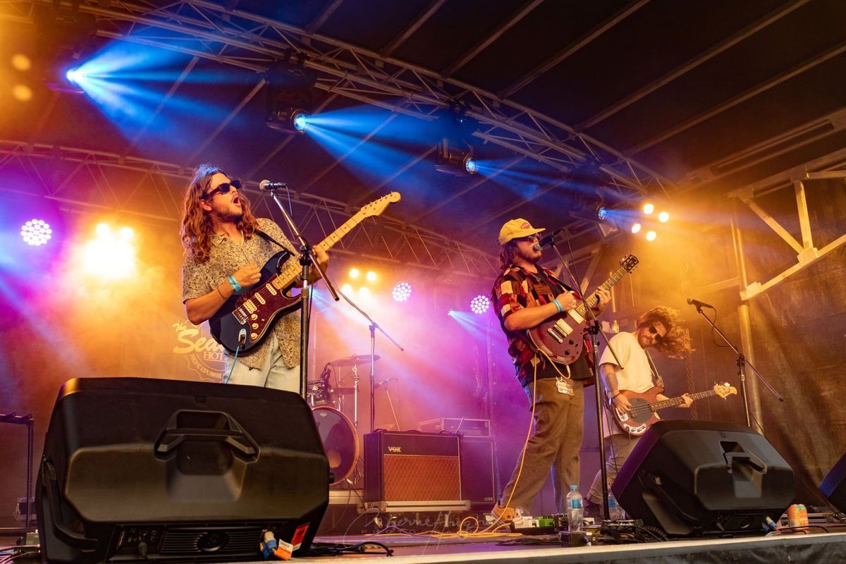 Band Performing On Stage With Guitars And Drums — Kennedy Amplifier Hire Service In South Mackay, QLD