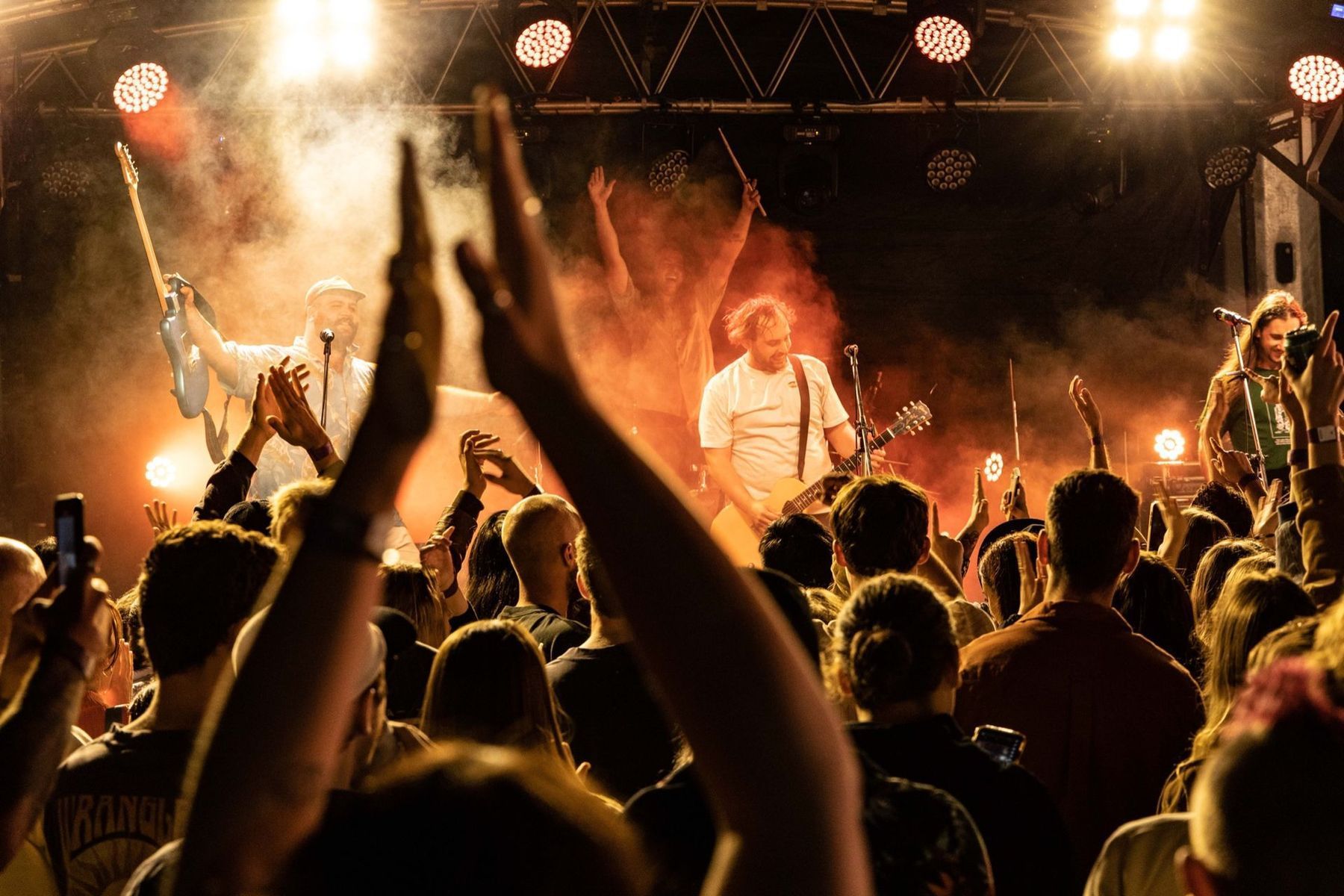 Band Performing On Stage With Crowd; Lights, Arms Raised — Kennedy Amplifier Hire Service In South Mackay, QLD