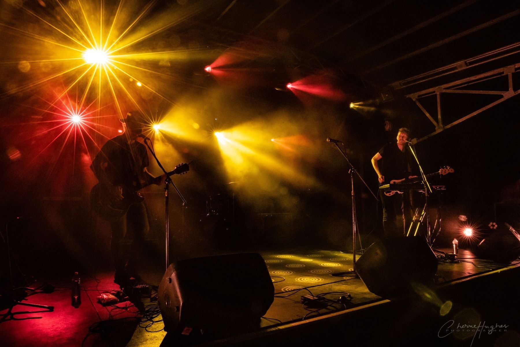 Band Performing On Stage With Bright Yellow And Red Stage Lights — Kennedy Amplifier Hire Service In South Mackay, QLD